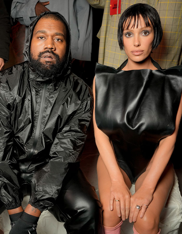 Two individuals seated, one in a black outfit; related to Kanye West's Super Bowl ad release.