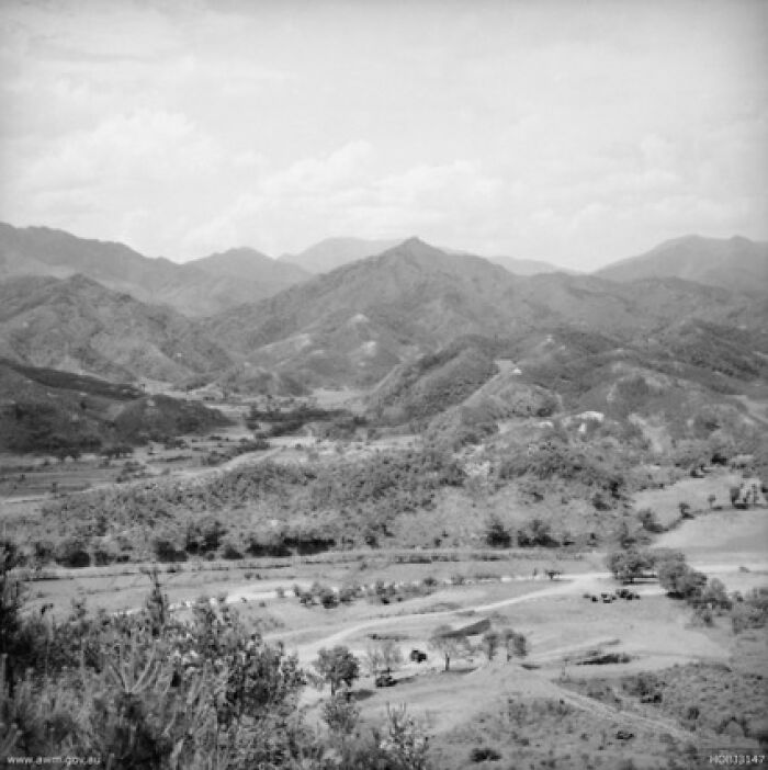 Mountainous terrain, site of surprising war victories, with rolling hills and sparse vegetation under a cloudy sky.