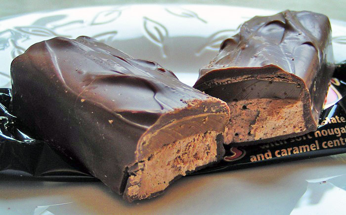 Chocolate bar cut in half revealing nougat and caramel, showcasing fascinating facts about chocolate composition.