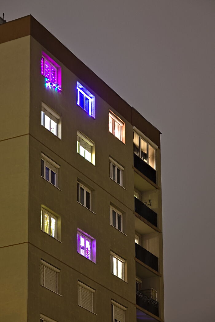 Hungary's panel building at night with colorful illuminated windows.