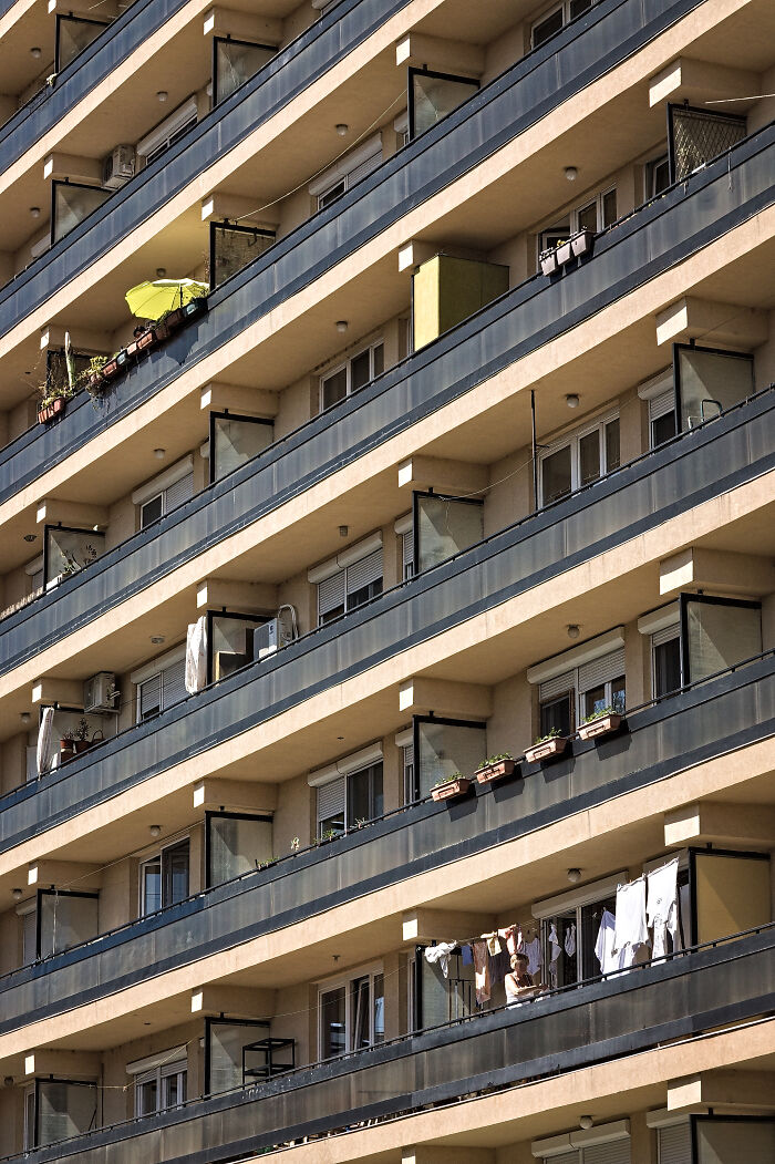 Hungary's panel building with balconies, laundry, and plants.