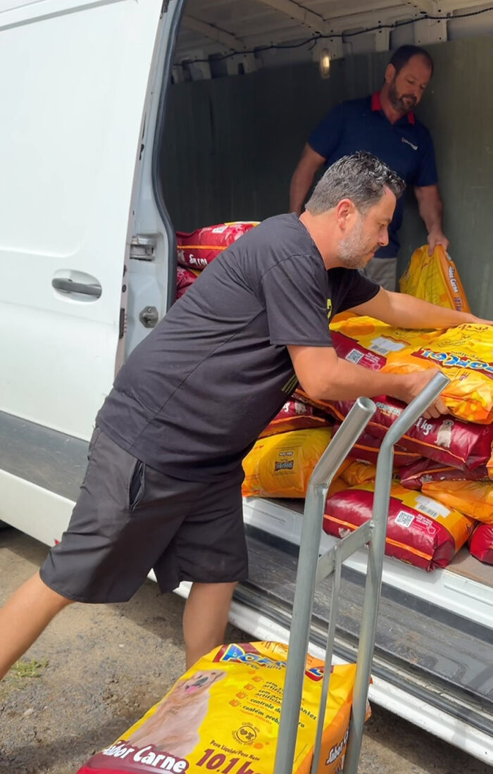 Man unloading dog food from a van, dedicated to feeding stray dogs for 25 years. Man unloading dog food from a van, dedicated to feeding stray dogs for 25 years.