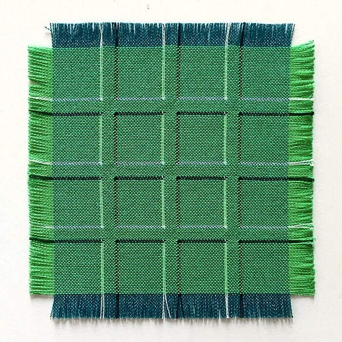 Intricate geometric weave art featuring a green and blue pattern creating optical illusions.