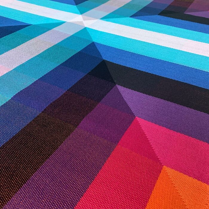 Intricate geometric weave art with vibrant colors forming an optical illusion.