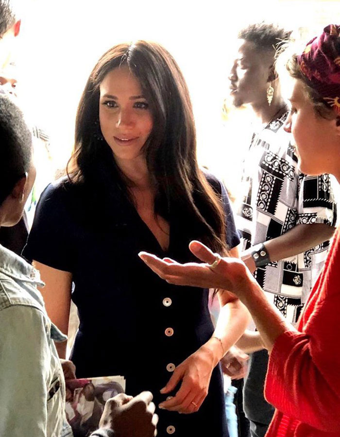 A woman in a dark dress interacting with people in a crowded setting, capturing Valentine's Day moment.