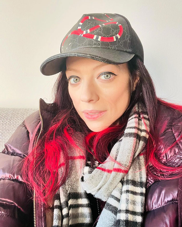 Person in a black cap and plaid scarf, with red highlights, presents a confident expression; theme relates to fan interactions. Person in a black cap and plaid scarf, with red highlights, presents a confident expression; theme relates to fan interactions.