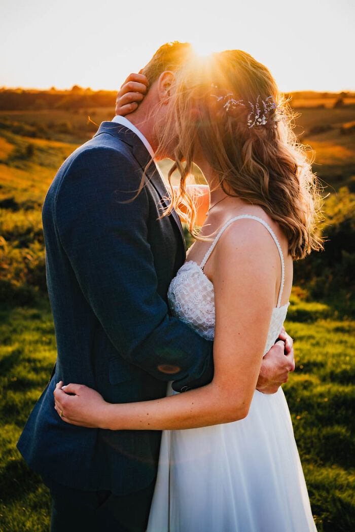 A couple embracing during a sunset, capturing the romance of wedding photographs.