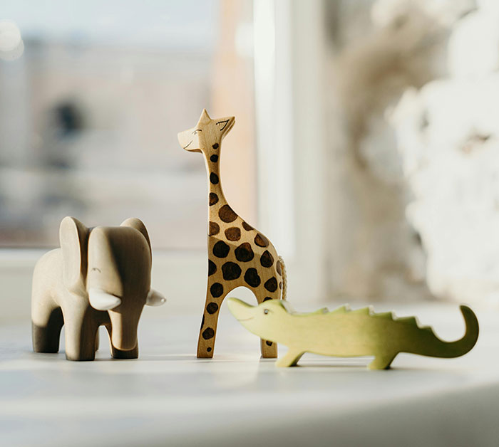Wooden animal toys, including an elephant and giraffe, symbolize birthday party demands discussion. Wooden animal toys, including an elephant and giraffe, symbolize birthday party demands discussion.