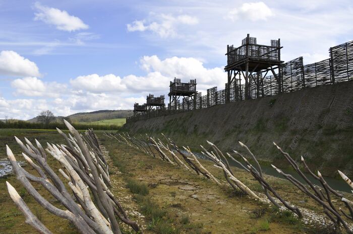 Ancient fortifications with wooden barricades and towers under a blue sky, illustrating surprising war victories.
