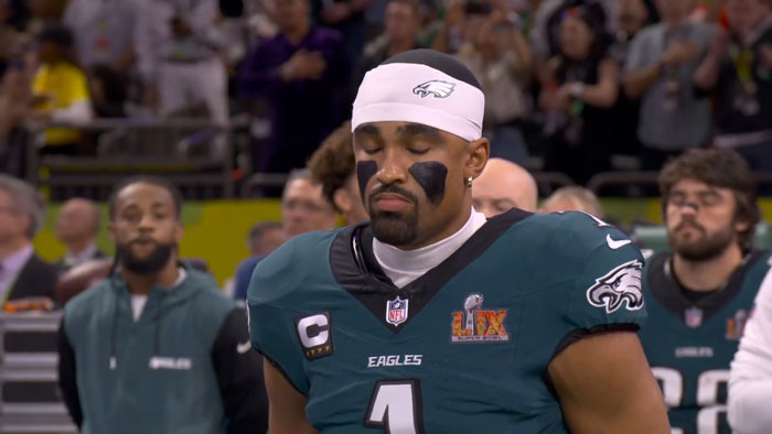 Eagles player during national anthem at Super Bowl LIX, eyes closed in focused moment. Eagles player during national anthem at Super Bowl LIX, eyes closed in focused moment.