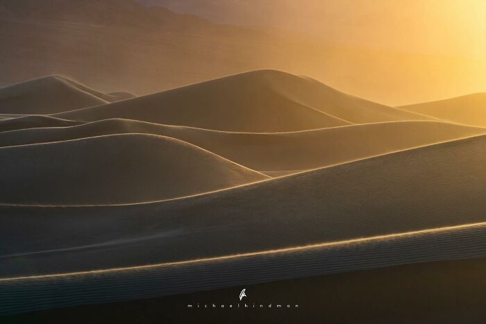 Golden light on sand dunes capturing the textures of nature in an intimate landscape photo by Michael Hindman.
