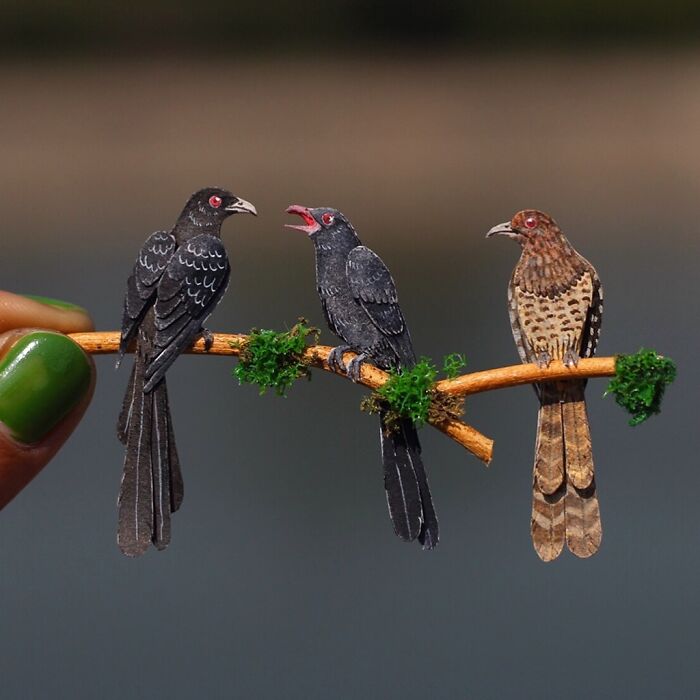 Miniature realistic paper art of three birds on a branch, highlighting animal conservation.
