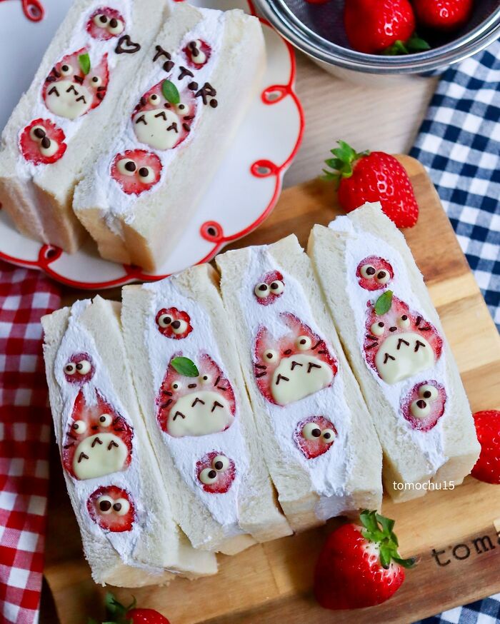 Creative lunchbox idea featuring sandwiches with cute character designs made from strawberries and cream.