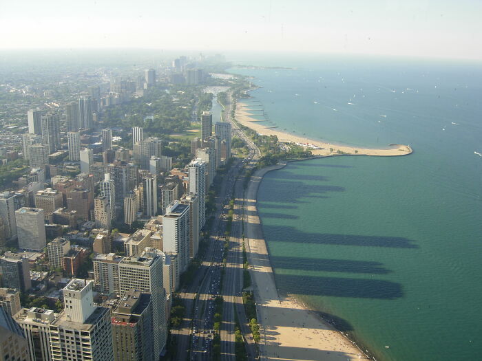 Aerial view of a city skyline along a coastal road, part of legendary American road routes.