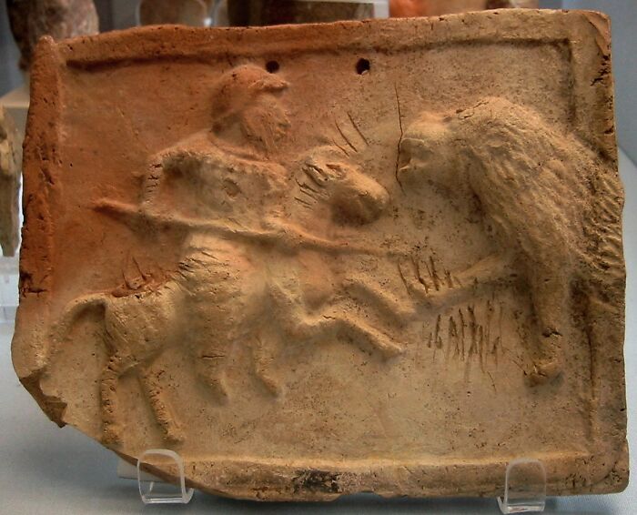 Ancient clay relief depicting a centaur battling a lion, symbolizing surprising war victories.
