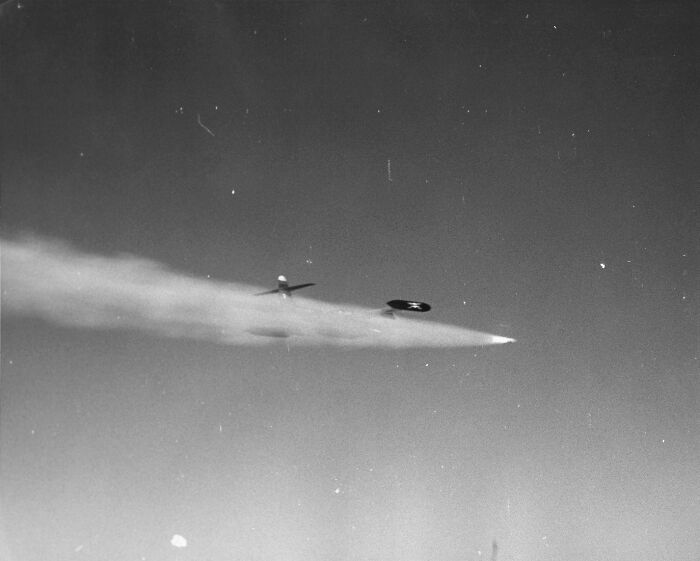 A mysterious flying object emitting smoke trails in a clear sky, representing weird government projects.