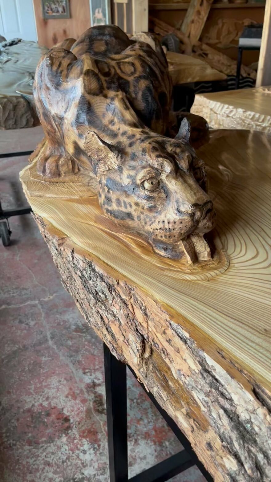 Chainsaw artist transforms a wooden log into an intricate sculpture of a detailed animal, showcasing craftsmanship.