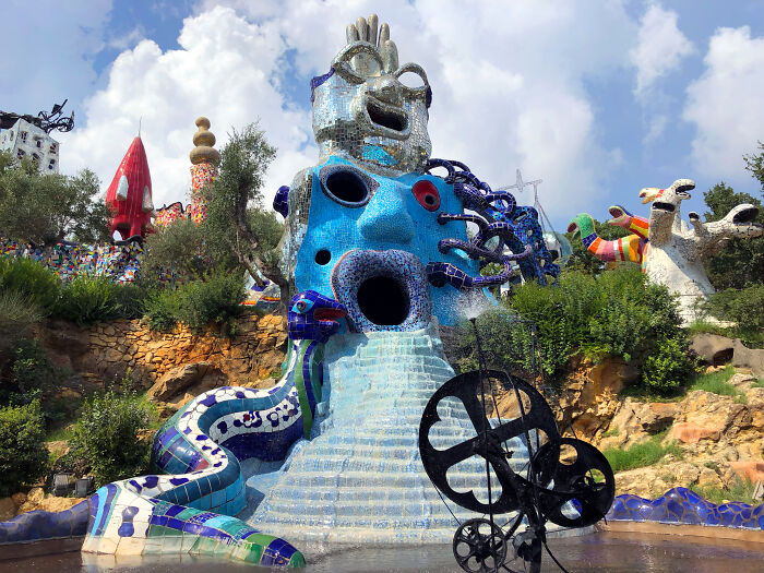 Colorful mosaic sculpture resembling a surreal creature, exemplifying beautiful useless buildings in artistic design.