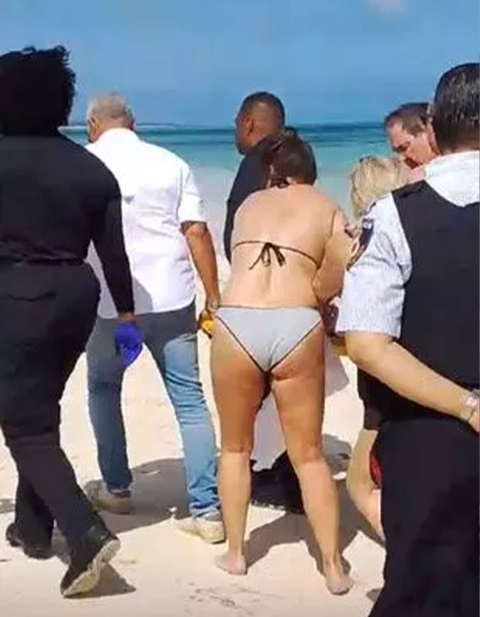 Beach scene with people assisting a woman injured by shark. Beach scene with people assisting a woman injured by shark.