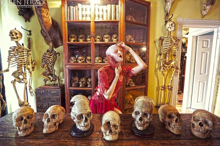 Unique model Melanie Gaydos posing creatively in a room with skeletons and skulls.