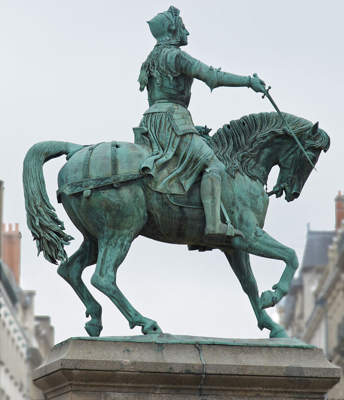 Bronze equestrian statue of a historical figure in armor, located in a city square, highlighting cool historical facts.
