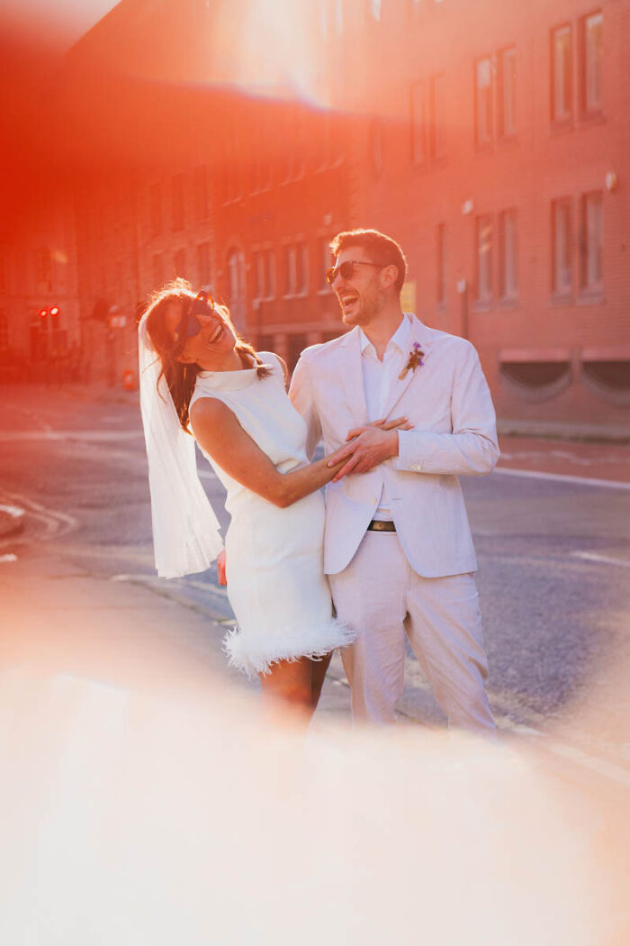 Bride and groom laughing in warm sunlight, showcasing a best wedding photograph of 2025.