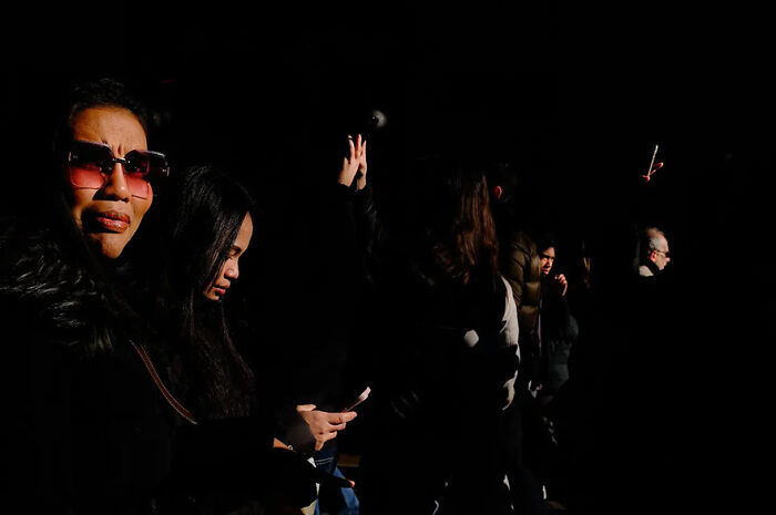 People captured in abstract street photography by Andrea Pozzoni, with striking light and shadow contrasts.