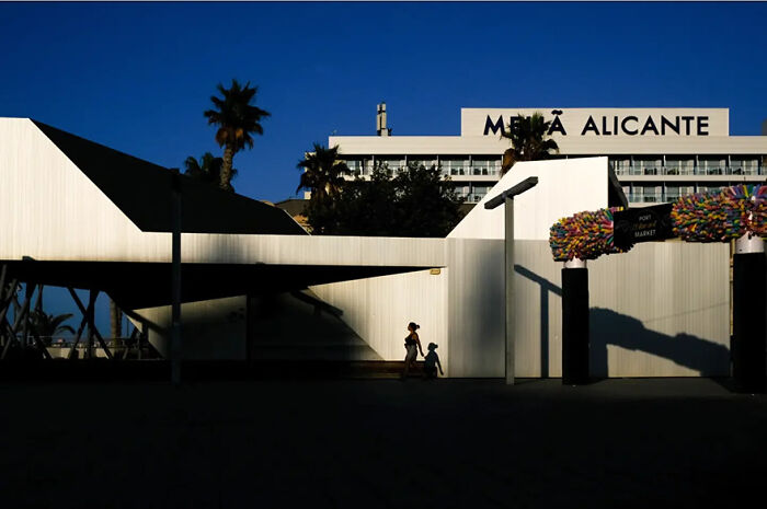 Abstract street photograph with dramatic shadows and a solitary figure by Andrea Pozzoni.