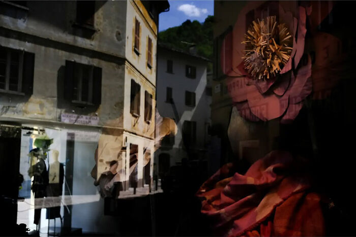 Abstract street photography featuring layered reflections and vibrant colors on a building facade.