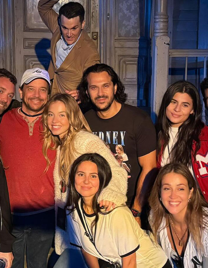 Group photo featuring Sydney Sweeney smiling with friends at an outdoor event.