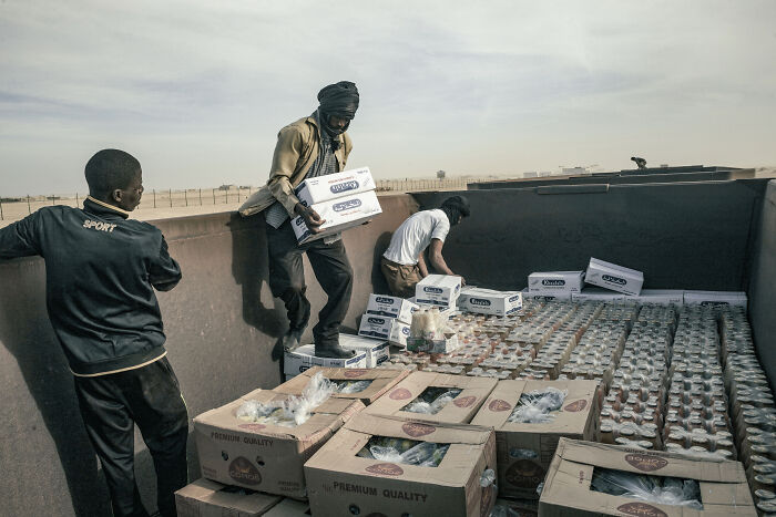 Mauritanian Traders Load Boxes With Juice, Bananas, And Couscous Onto The Cargo Carriage Of The Iron Ore Train