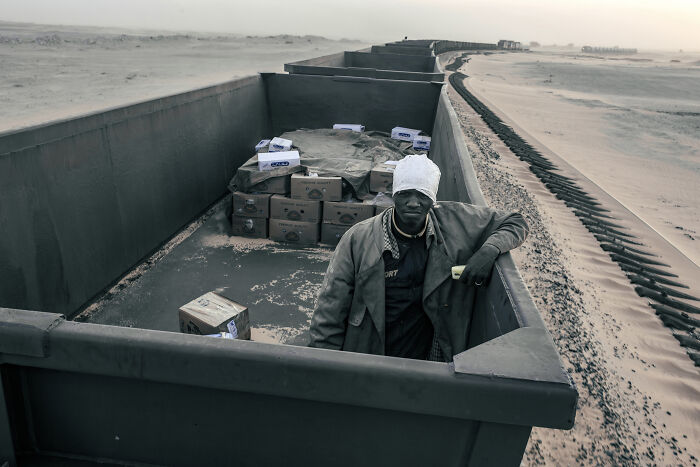 Mauritanian Man Rides Inside A Cargo Carriage Of The Iron Ore Train Between Nouadhibou And Zouerat