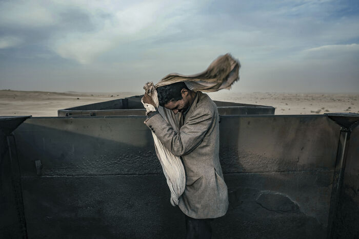 Mauritanian Man Fixes His Headscarf While Riding The Iron Ore Train Along The Moroccan Border