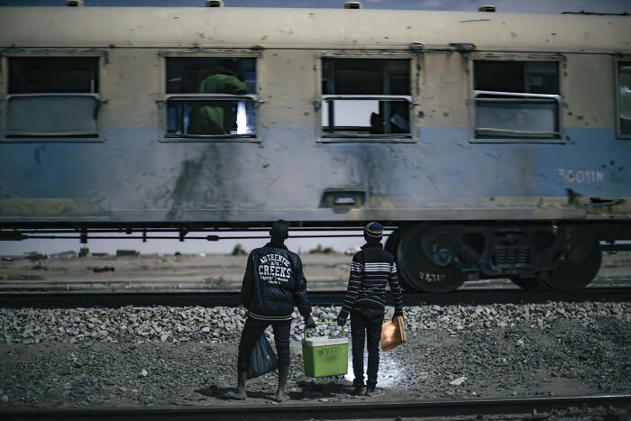 Mauritanian Youngsters With A Cooler Bag Try To Sell Some Cold Drinks To The Passengers Of The Iron Ore Train. This Is The Last Carriage Of The Train And The Only One Dedicated To Passengers