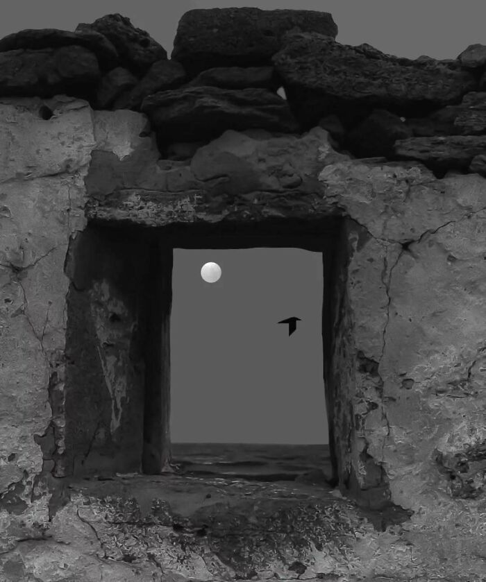 Minimalism and mystery with a moon and bird seen through an ancient stone window, capturing surreal tranquility.
