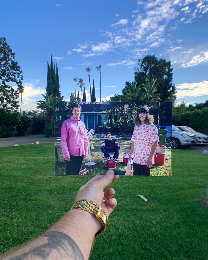 A hand holds a photo at a famous location, aligning iconic scene with the real background, showcasing history and change.
