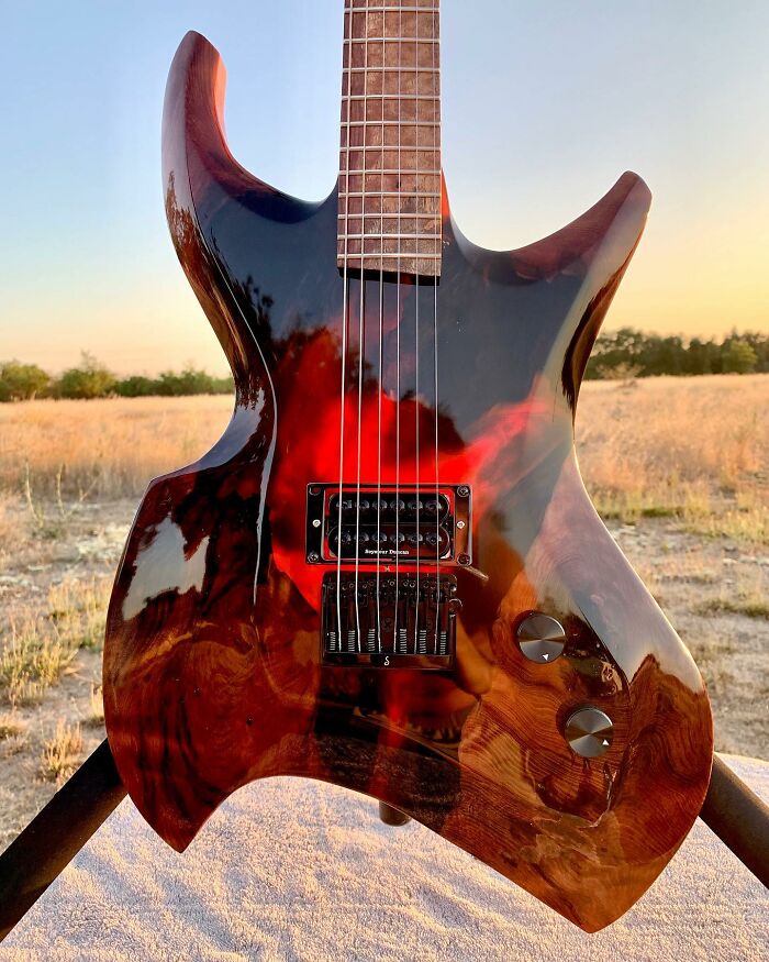 Unique guitar crafted from unexpected materials, showcasing a sleek design against a scenic outdoor backdrop.