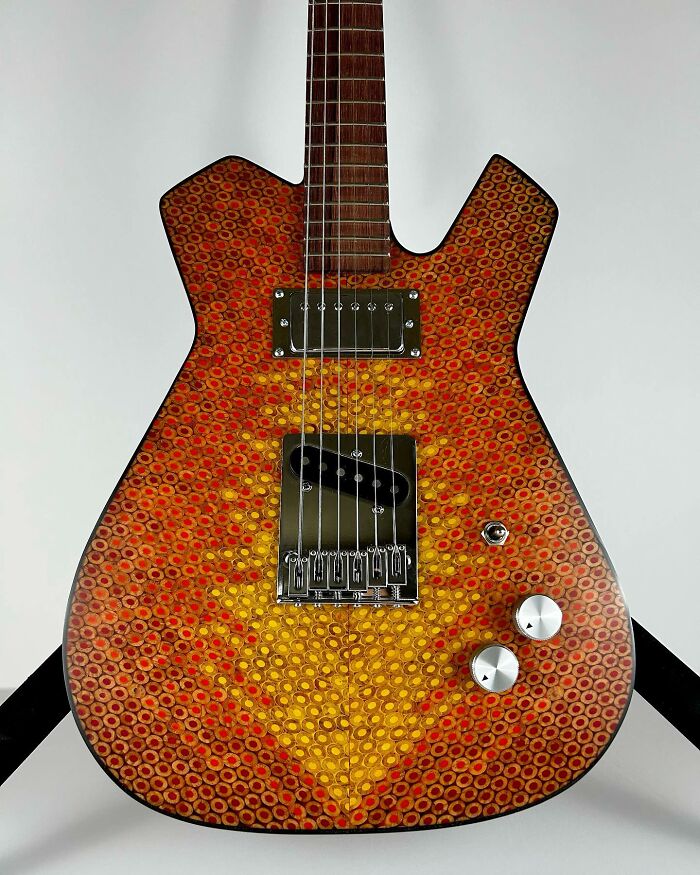 Guitar crafted from unique materials with a colorful, circular pattern design.
