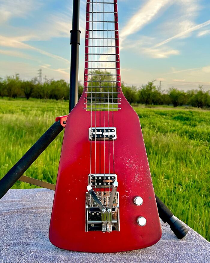 Unique guitar crafted from unexpected materials, displayed outdoors.