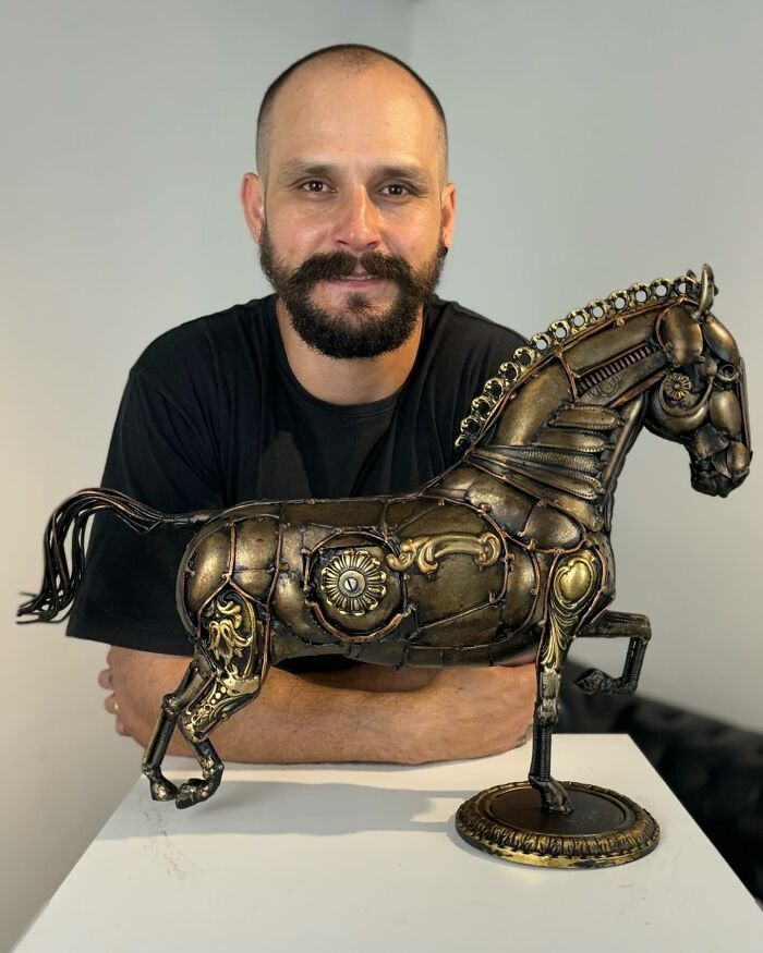 Artist with a scrap metal horse sculpture, showcasing intricate design work.