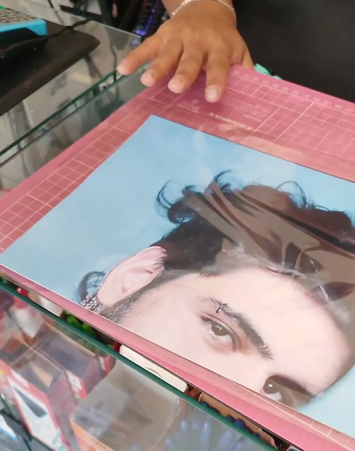 Prankster's hand holding a humorous photo in a playful family prank.