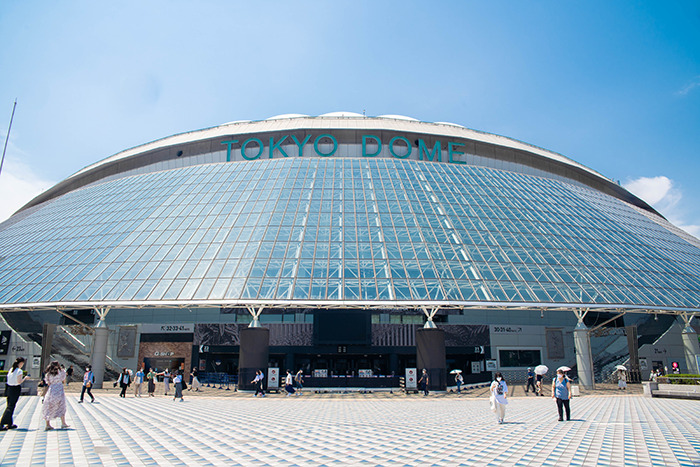 Tokyo Dome exterior on a sunny day, showcasing its modern architecture. Tokyo Dome exterior on a sunny day, showcasing its modern architecture.
