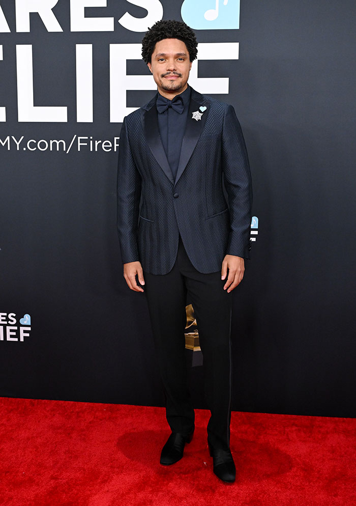 Man in sleek blue suit on red carpet at 67th Grammy Awards, presenting a standout outfit.