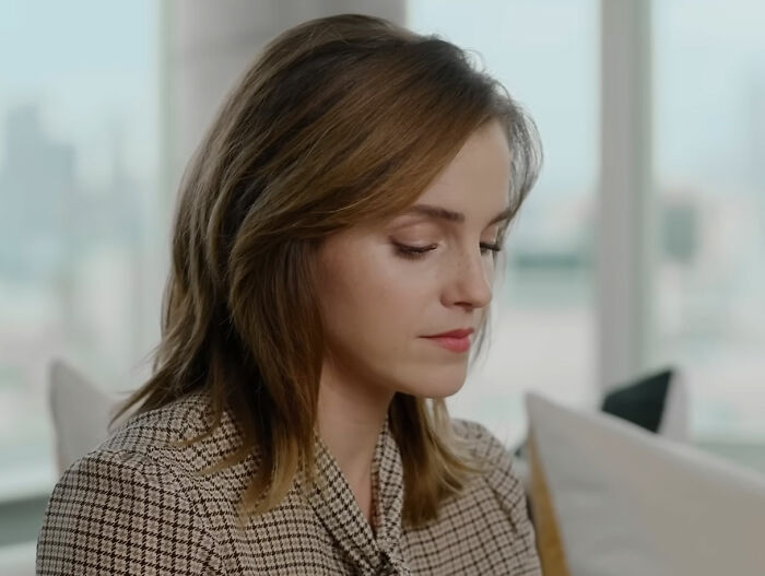 Person sitting in a bright room, wearing a checkered outfit, with a calm expression, reflecting on a celebrity insight.