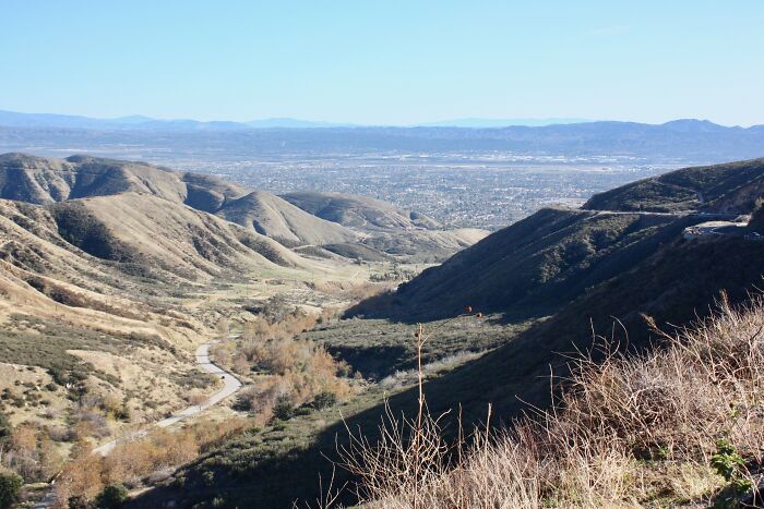 Scenic view of a legendary American road route winding through rolling hills under a clear blue sky.