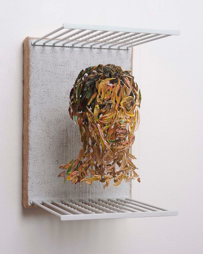 Three-dimensional painting of a head by Chris Dorosz, featuring colorful strokes suspended on vertical threads.