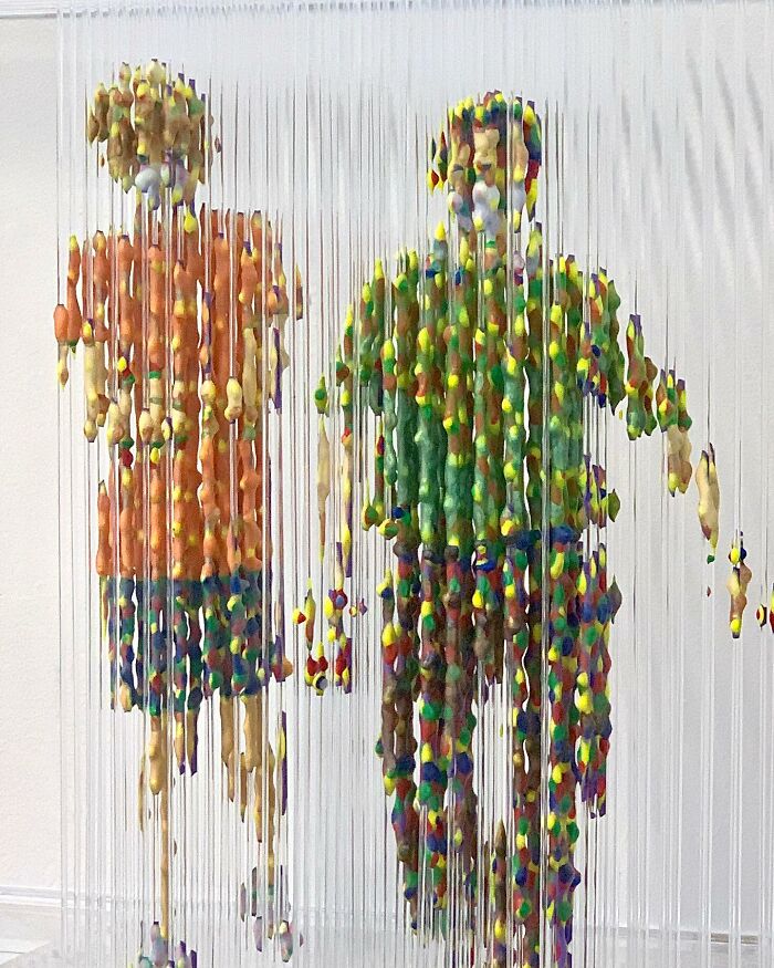Fragmented, three-dimensional painting of two people by Chris Dorosz, featuring colorful suspended elements.