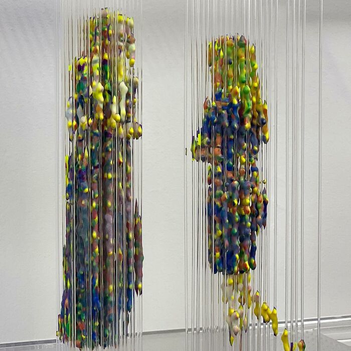 Three-dimensional, fragmented painting of two figures by Chris Dorosz, using colorful suspended beads.