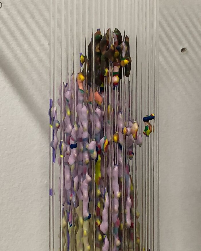 Three-dimensional painting of a person by Chris Dorosz, featuring colorful fragments suspended on vertical rods.