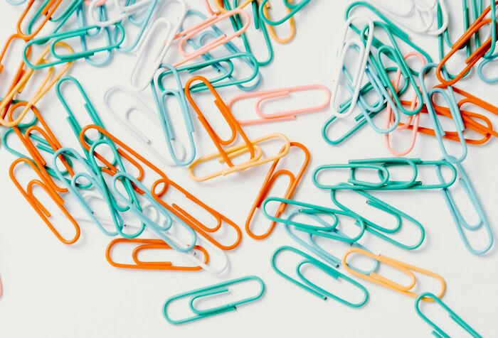 Colorful paper clips scattered on a surface, representing beautifully designed durable items.